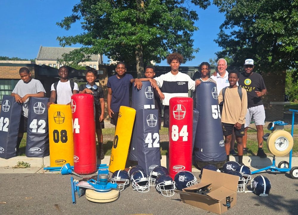Detroit City Lions youth athletes with donated football dummies, helmets and training equipment